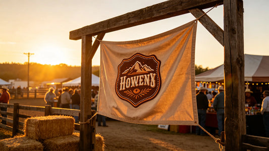 Outdoor rodeo merchandise booth, custom western‑themed 3D foam embroidered patch attached to canvas display banner, spectators wandering in background