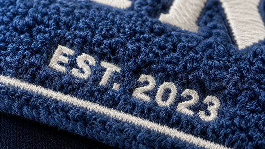 Perfectly readable micro-typography and fine text details achieved with mixed media flat embroidery on a chenille patch.