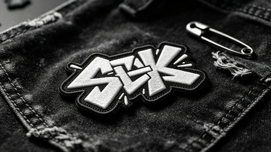 Single graffiti-style 3D raised embroidery patch for streetwear brands, foam embroidery texture laid on vintage black washed denim fabric.