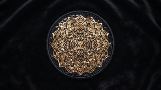 An ultra-high-definition, 16:9 wide-aspect shot centered on a single, flawless, round flip-sequin patch. The patch, set on a broad expanse of deep black velvet background extending to the edges, uniformly features an intricate, full, symmetrical golden mandala design. All sequins are perfectly aligned and brushed to reveal only the single golden pattern. There is no text or division line.