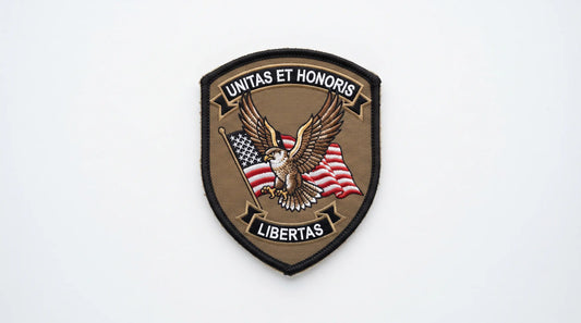 A full view of a single, rigid, shield-shaped tactical cap patch with detailed embroidery and precise laser-cut edges.